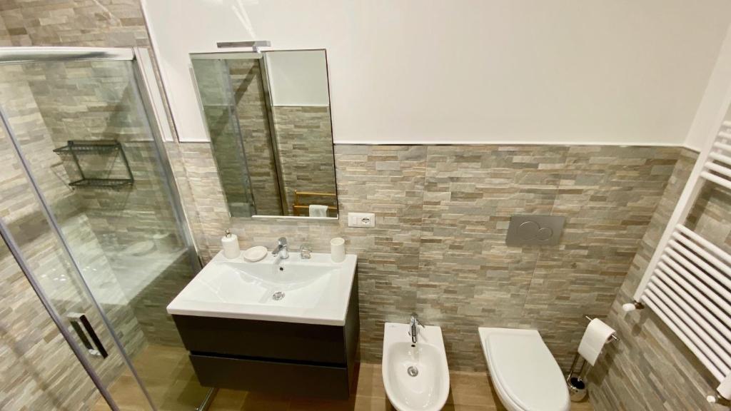 a bathroom with a sink and a toilet and a mirror at Cala Portavecchia in Monopoli