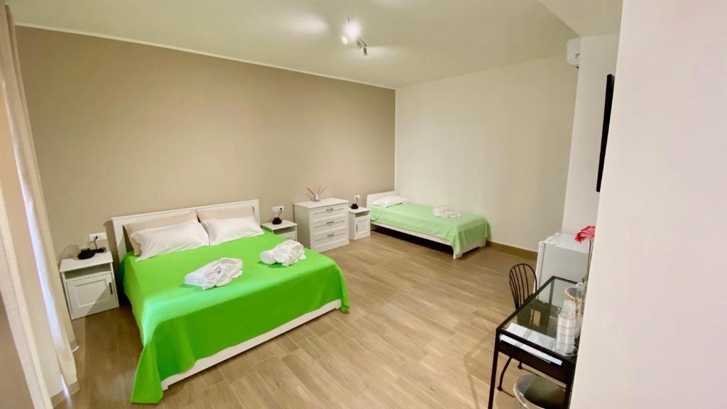 a bedroom with two green beds and a desk at Cala Portavecchia in Monopoli