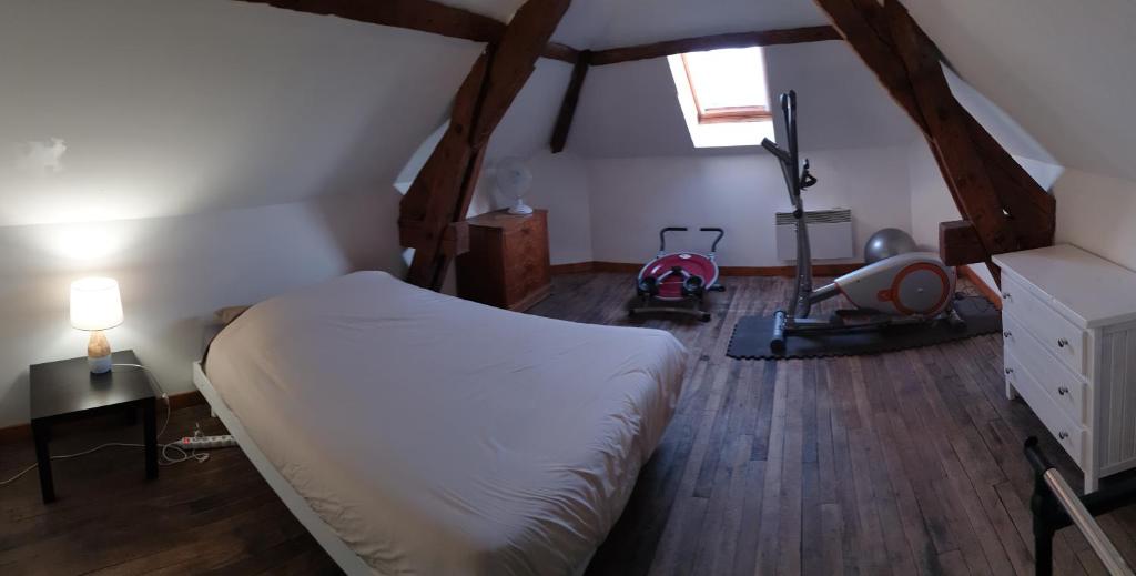 een slaapkamer met een bed, houten vloeren en een raam bij Appartement agréable 1 à 4 personnes in Chaumont
