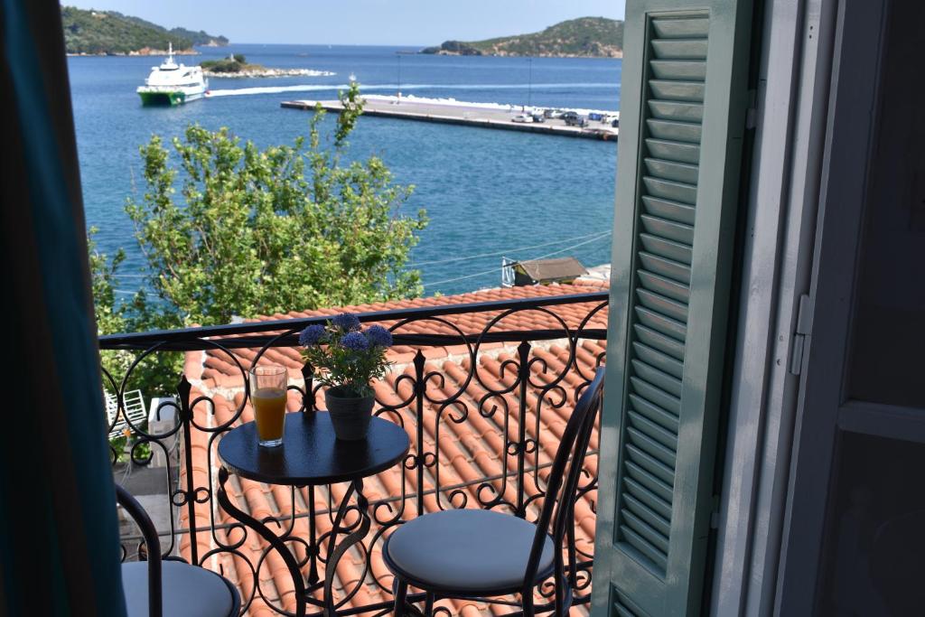 a balcony with a table and chairs and a view of the water at Pension Ververi in Skiathos