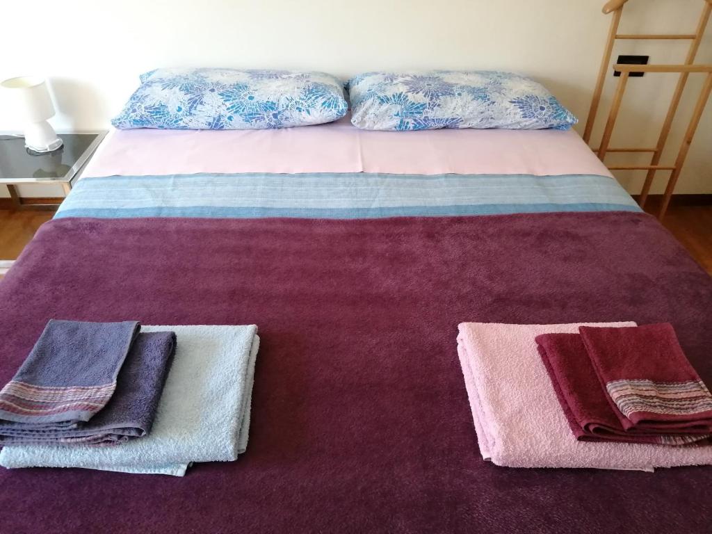 een bed met handdoeken bovenop bij Bed and Breakfast Relax in Trento