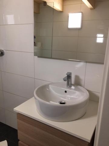 a bathroom with a white sink and a mirror at Serviced Apartement Sonnleitner in Furth
