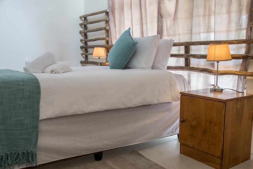 a bedroom with a bed with two lamps on a table at Leeville Guesthouse in Kasane