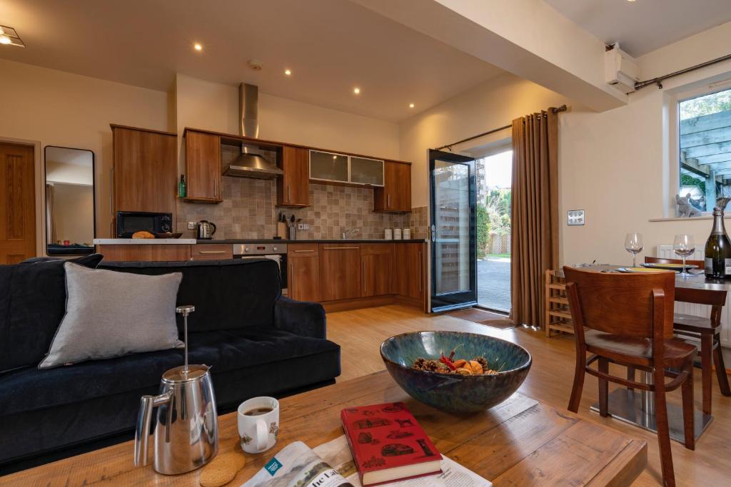 sala de estar y cocina con sofá y mesa en Lodge House - Windermere - Private Garden en Windermere