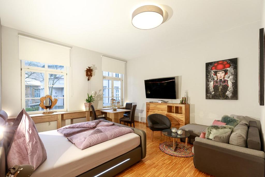 - un salon avec un canapé et une télévision dans l'établissement Schwarzwaldzimmer & Schwarzwald Design Apartment, à Rottweil