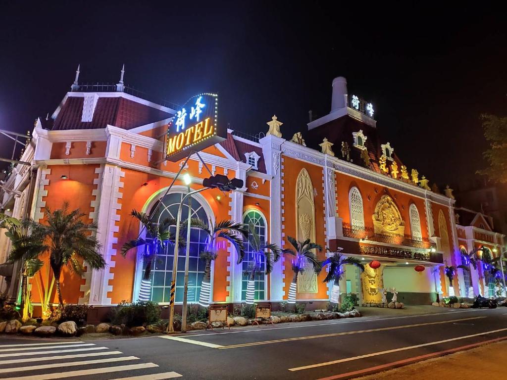 um edifício com um letreiro de néon em frente em Holland Hill Motel em Tainan