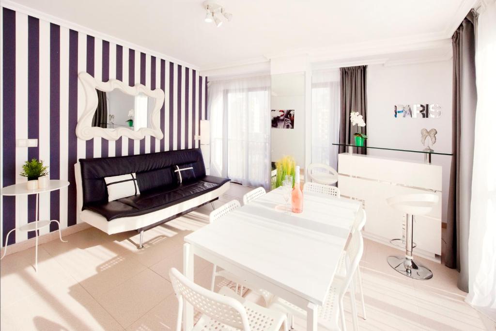 a living room with a white table and chairs at My Pretty Payma Apartamentos in Benidorm
