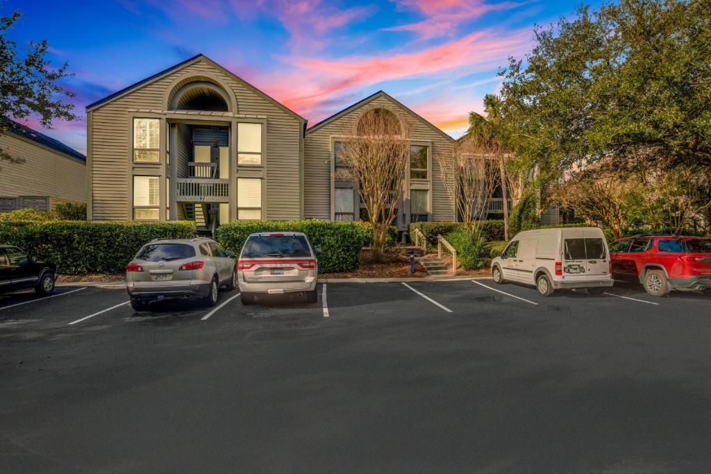 a house with cars parked in a parking lot at Pelican Watch 1380 in Seabrook Island