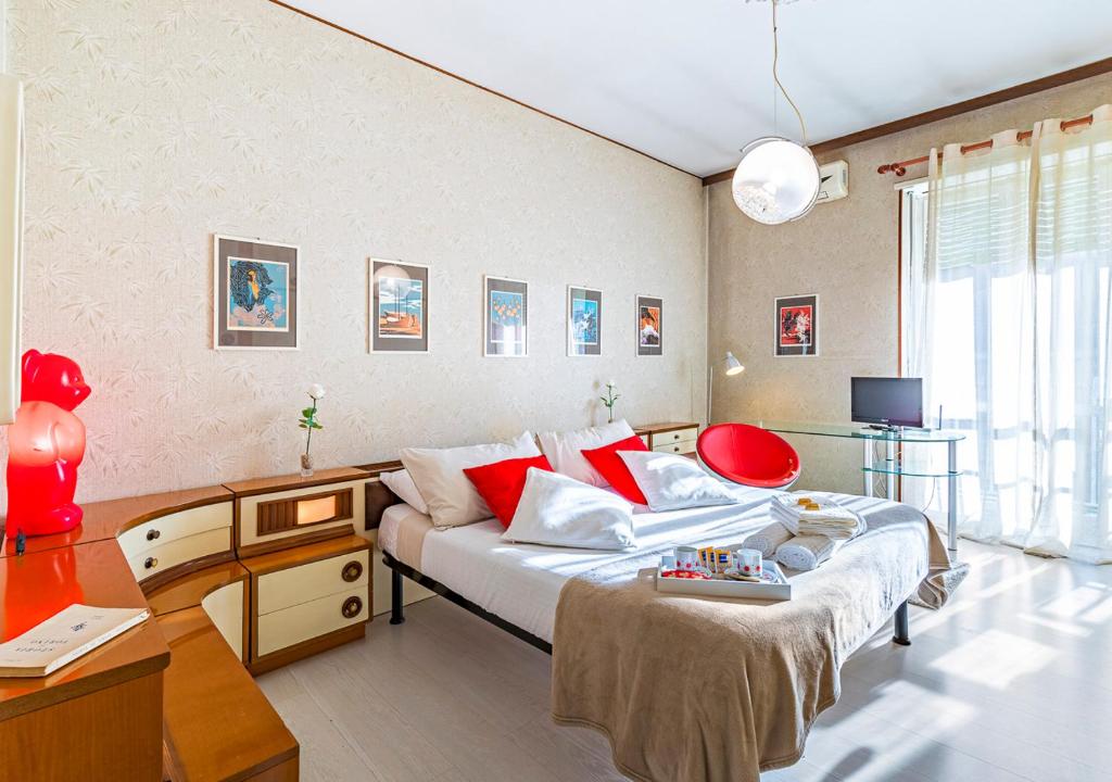 um quarto com uma cama com almofadas vermelhas e uma secretária em 70's Lovers Apartment in Turin em Turim