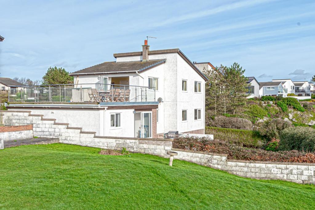 una gran casa blanca con un gran patio en Trearddur Bay - Home with a view and Hot Tub - Sleeps 10 en Trearddur