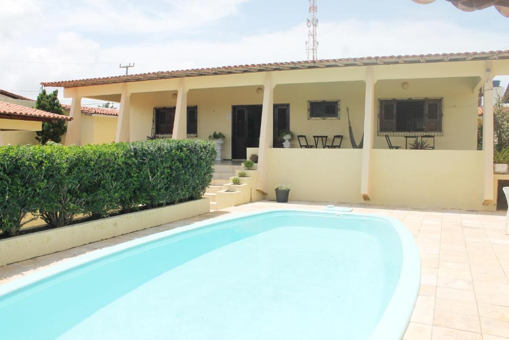 a swimming pool in front of a house at Hotel Pousada Calhau in São Luís
