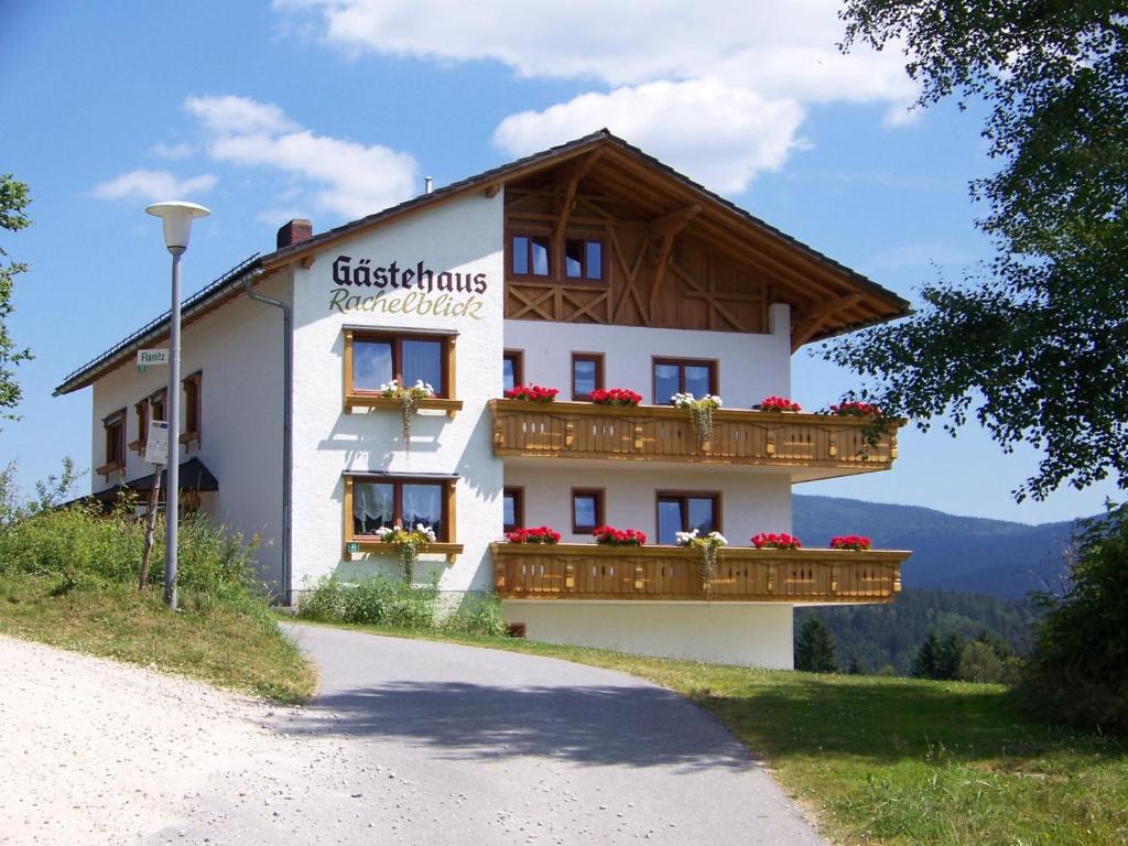 a large white building with flowers on the balconies at Gästehaus Rachelblick in Frauenau