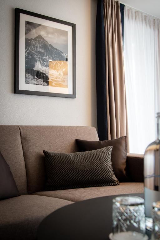a living room with a couch and a window at Walliserhof Grand-Hotel & Spa Relais & Châteaux in Saas-Fee