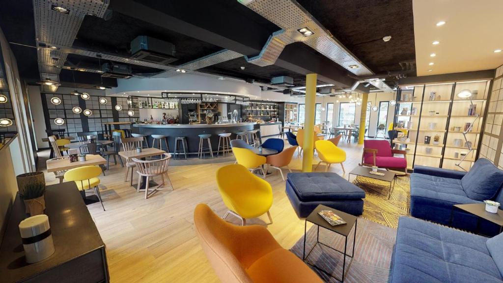 a store with colorful chairs and tables and a bar at Campanile Fontainebleau in Fontainebleau