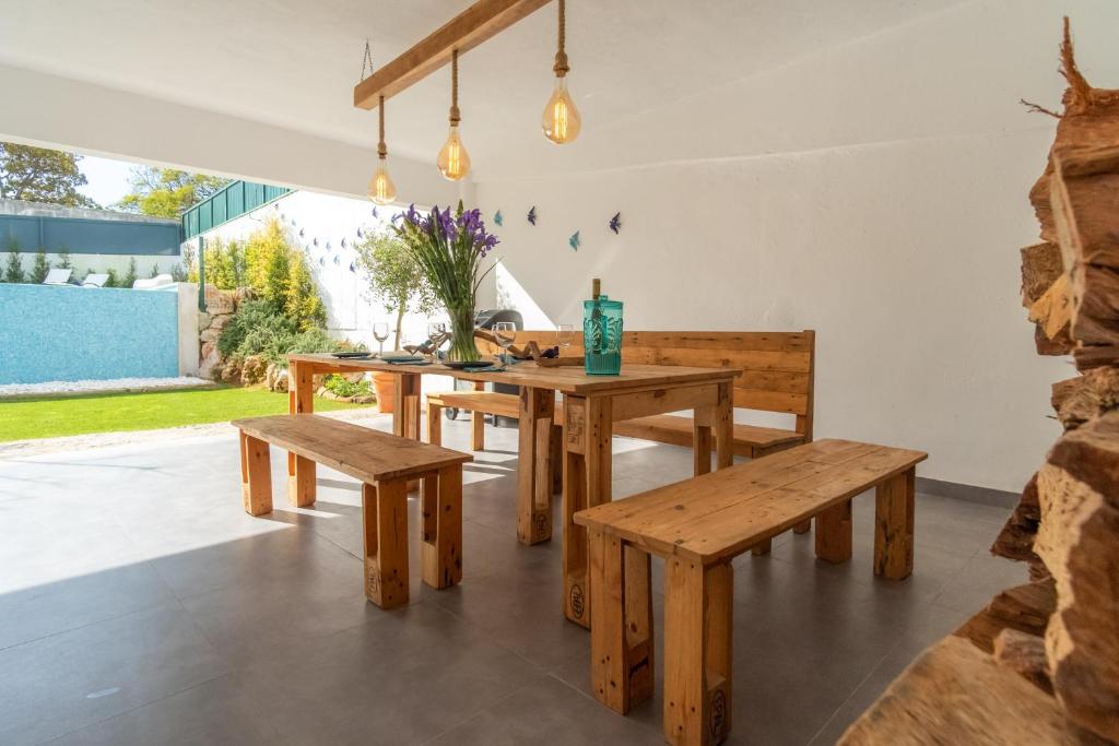 a dining room with wooden tables and benches at Casa em Cascais in Cascais