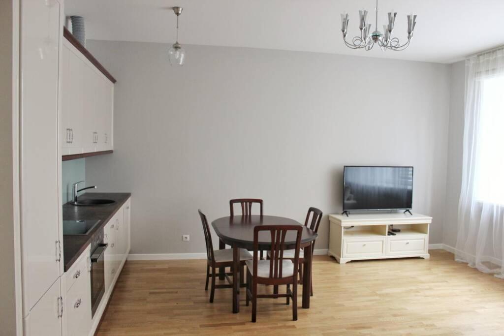 Una cocina con mesa y sillas y un televisor. en Riga Central Park Apartment, en Riga
