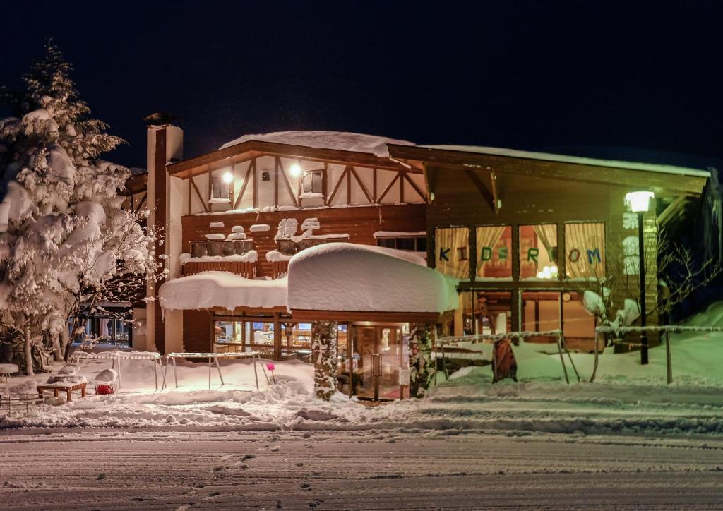 a building covered in snow at night at New Yokote in Yamanouchi