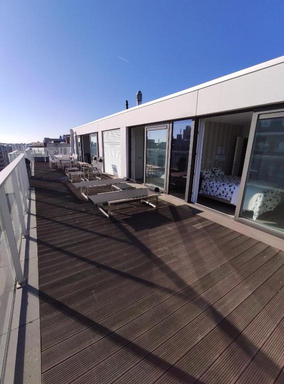 eine Terrasse mit Bänken auf einem Gebäude in der Unterkunft Penthouse met groot terras Oostende in Ostende