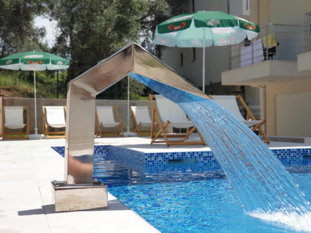 a water slide in a swimming pool with an umbrella at GREJM Lux Family Apartments in Petrovac na Moru