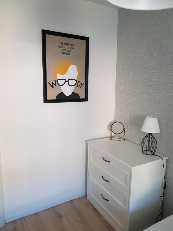 sypialnia z komodą i zdjęciem na ścianie w obiekcie Apartament Monika w Kłodzku