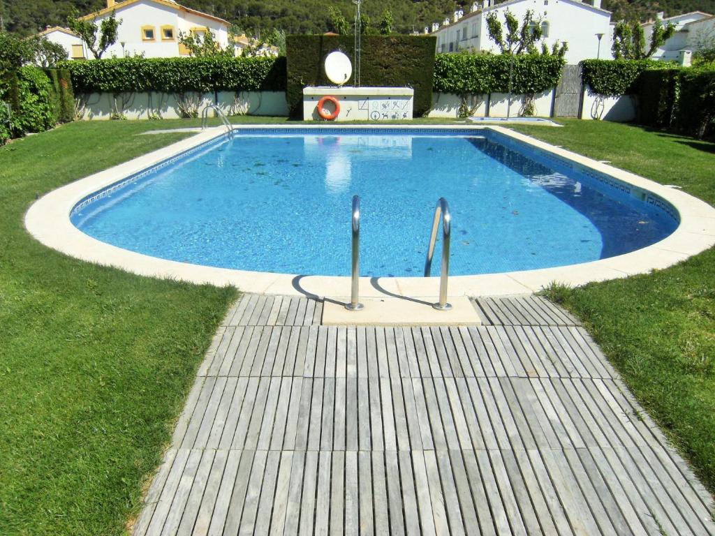 a swimming pool with blue water in a yard at TARRACO 20 (BOLLERIA) in L'Estartit