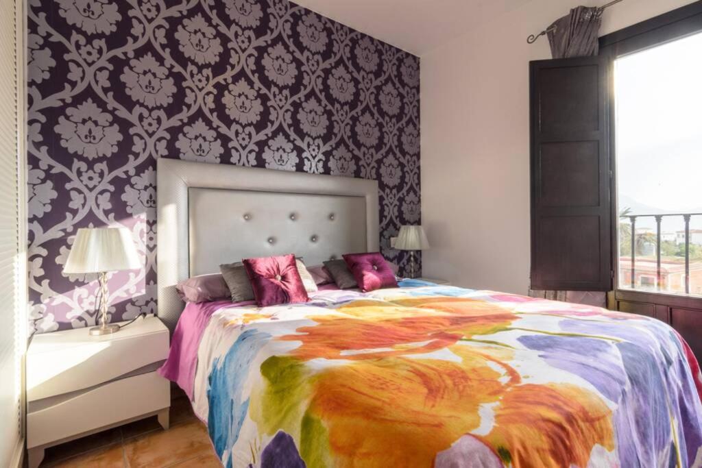 a bedroom with a large bed with a colorful comforter at MIRADOR DEL VALLE in Vélez de Benaudalla