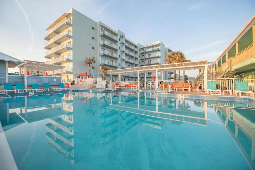 - une piscine en face d'un immeuble dans l'établissement Coconut Palms Beach Resort II a Ramada by Wyndham, à New Smyrna Beach