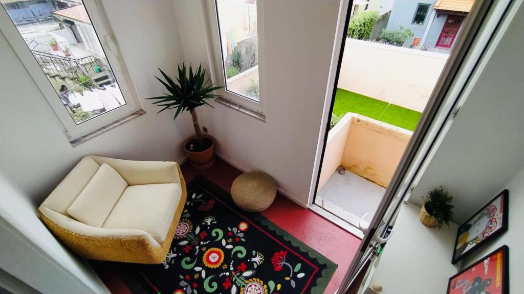 ein kleines Zimmer mit einem Stuhl und einem Spiegel in der Unterkunft Espinho Guesthouse - Garden House in Espinho