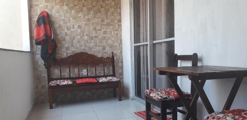 um pequeno quarto com uma mesa e uma janela em Casa Cantinho da Família - Praia de Guaibim - em Guaibim