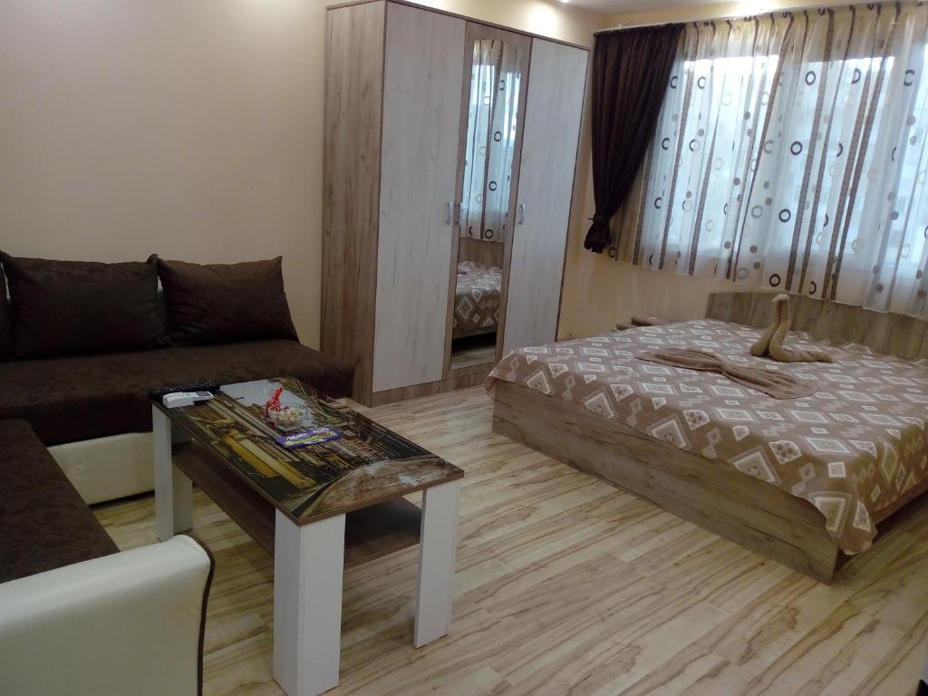 a living room with a bed and a couch at Апартамент ДАНИ in Kazanlŭk