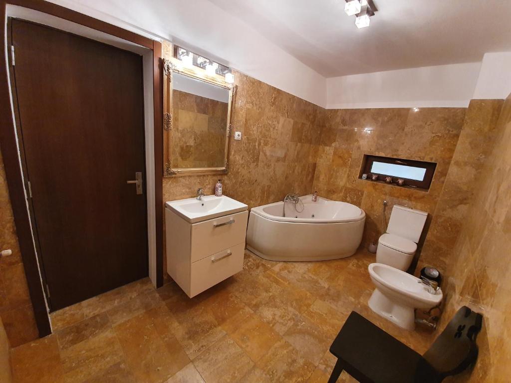 y baño con bañera, lavabo y aseo. en Vila De la Lugas, en Oradea