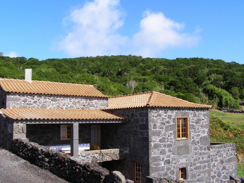 a stone house with a tile roof at Casa do Bernardo in Feiteira