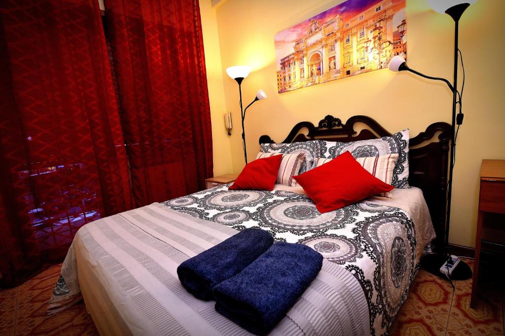 um quarto com uma cama com almofadas vermelhas e azuis em Roma Tiberius Suite em Roma