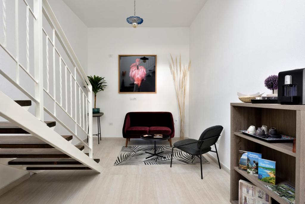 - un salon avec un escalier et une chaise rouge dans l'établissement INAH Rooms, à Dorgali