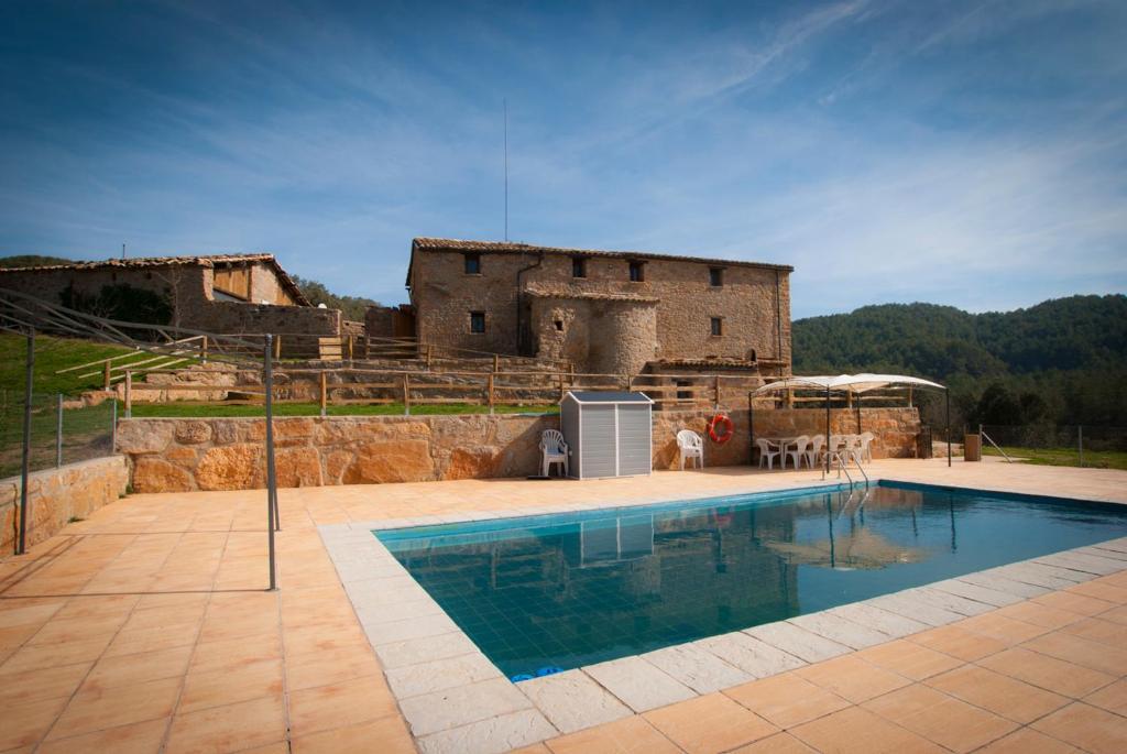 una gran piscina frente a un edificio en Masia l`Arà, en La Baronia de Rialb