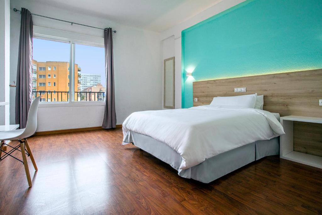 una camera con un grande letto e una grande finestra di Hotel Torremolinos Centro a Torremolinos