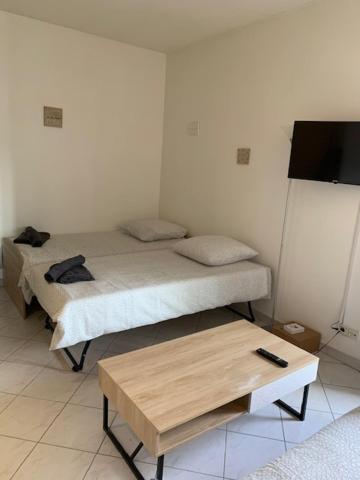 a room with two beds and a table and a tv at Studio CENTRE CROISETTE in Cannes