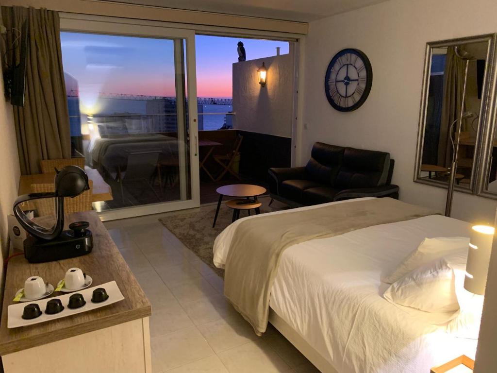 a bedroom with a bed and a balcony with a clock at SOLARIS PANORAMIC studio vue mer in Portimão