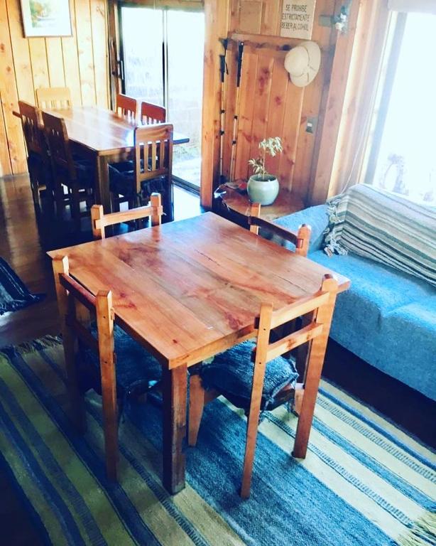 un tavolo e delle sedie di legno in una stanza di Hostal Andalue a Puerto Fuy