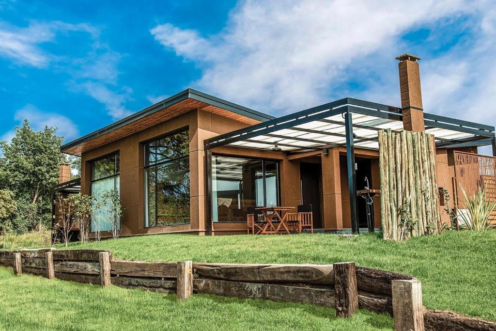 a house with a fence in front of it at Ventania Golf Resort in Sierra de la Ventana