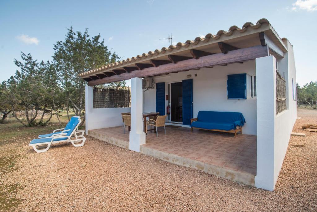 una piccola casa bianca con patio e due sedie di CASA GORKA Cala Saona a Cala Saona