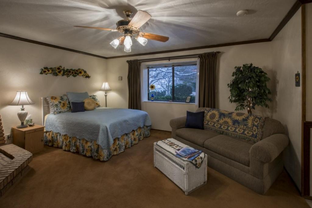 a bedroom with a bed and a couch and a ceiling fan at Canyon Colors Bed and Breakfast in Page