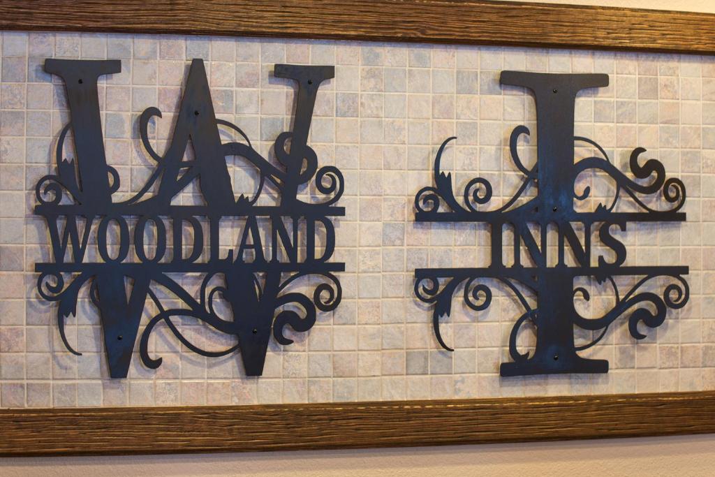 a sign for a wood island inn on a wall at Woodland Inns in Forks