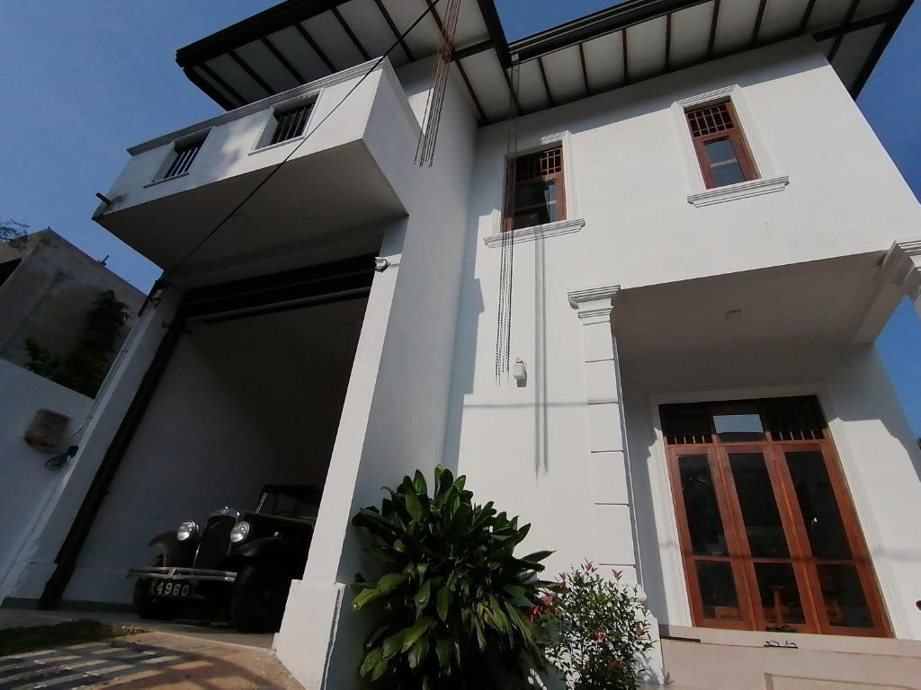 a white house with a door and a window at Weeraman's Vila in Kadawata