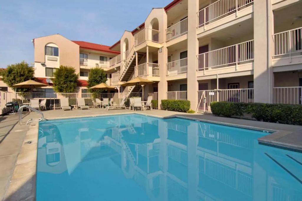 a swimming pool in front of a apartment building at California Inn and Suites, Rancho Cordova in Rancho Cordova