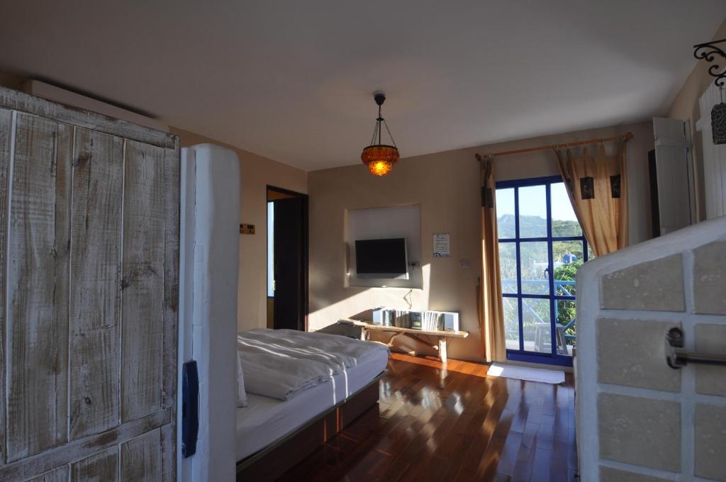 a bedroom with a bed and a tv and a window at Little Path Kenting in Eluan