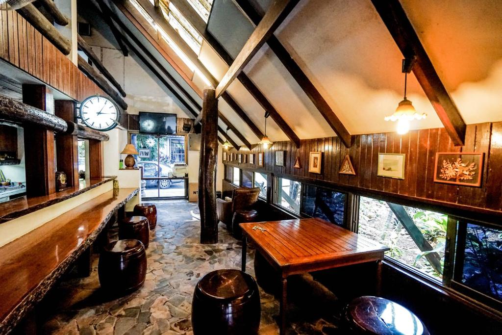a room with a table and chairs and a clock at Baan Chai Dan in Thong Pha Phum