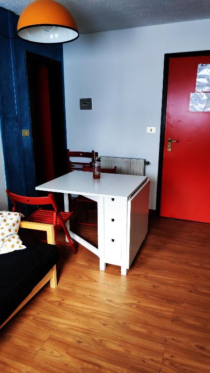 a room with a white desk and a red door at A due passi dal cielo in Passo del Tonale