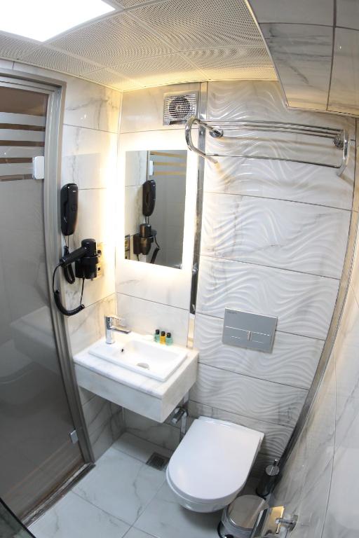 ein Bad mit einem WC und einem Waschbecken in der Unterkunft X-NELLYİ HOTEL in Istanbul