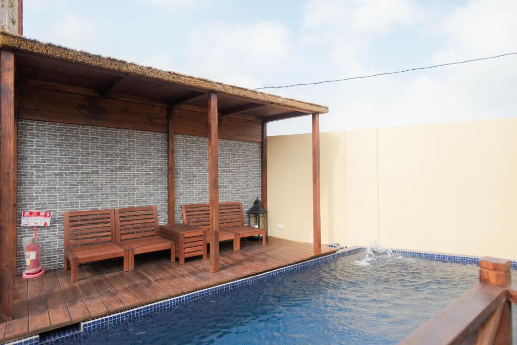 馬公市的住宿－月橘Villa，一个带两个长椅的庭院,毗邻游泳池